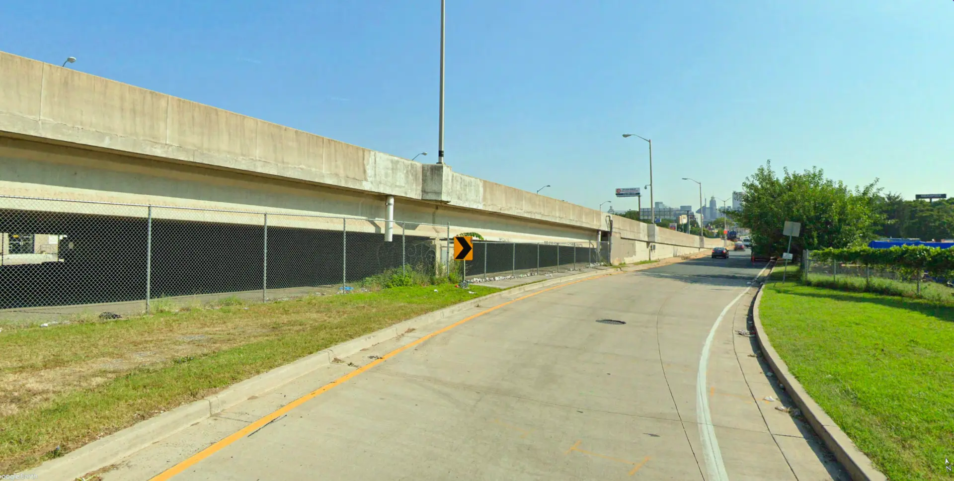 Russell Street approach beneath the I-95 overpass today, with bare concrete retaining walls and chain-link fencing