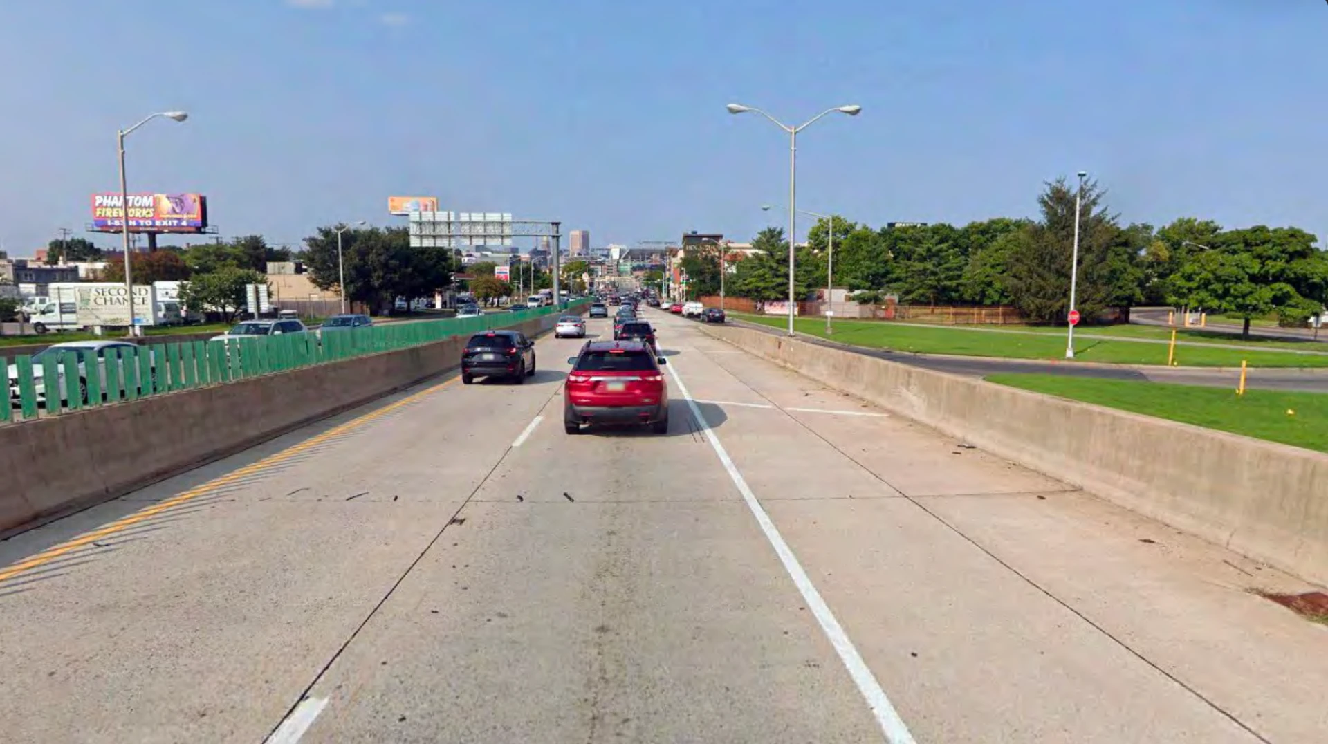 Russell Street northbound approach from I-95 today, concrete barriers and green fencing framing the drive into downtown